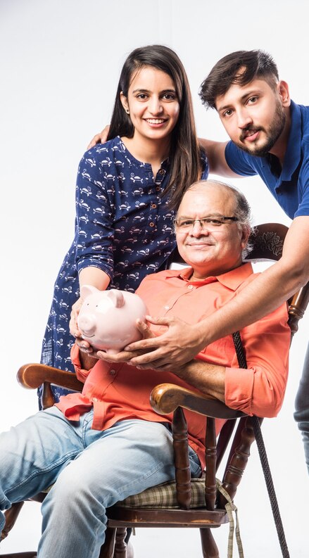 [freepicdownloader.com]-indian-old-man-father-holding-piggy-bank-with-young-son-daughter-sitting-rocking-chair-medium.jpg